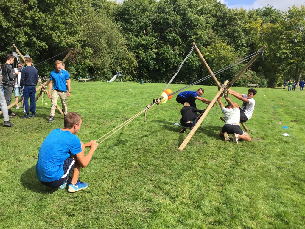 Teambuilding in volle gang: deelnemers aan klimbos Klimpark Streekbos demonstreren hun vaardigheden met zelfgemaakte katapulten. Een van de onderdelen uit het knal-arrangement.